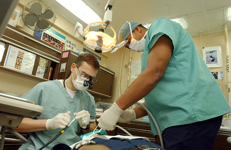 dentist and dental assistant performing oral surgery