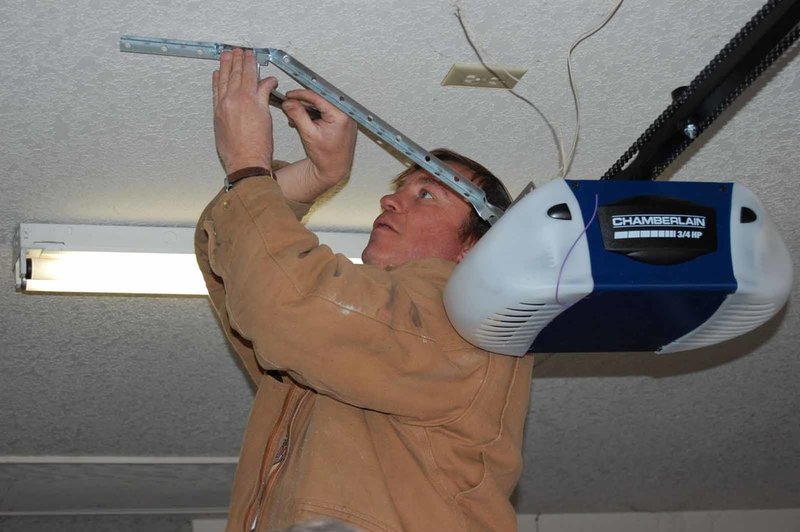 man performing automatic garage door maintenance