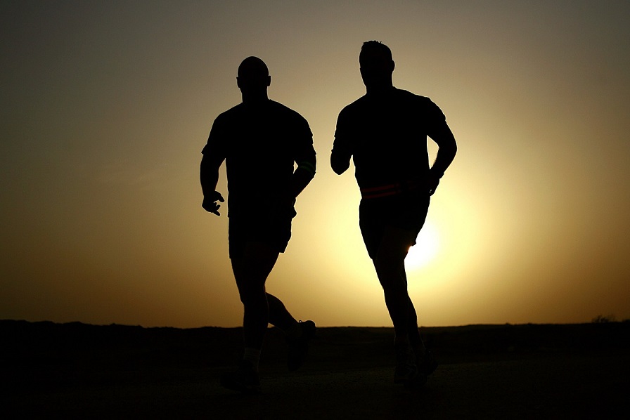 silhouette of two men running