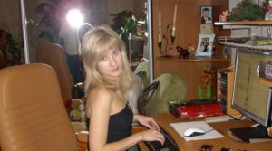 blonde woman on desk working on computer