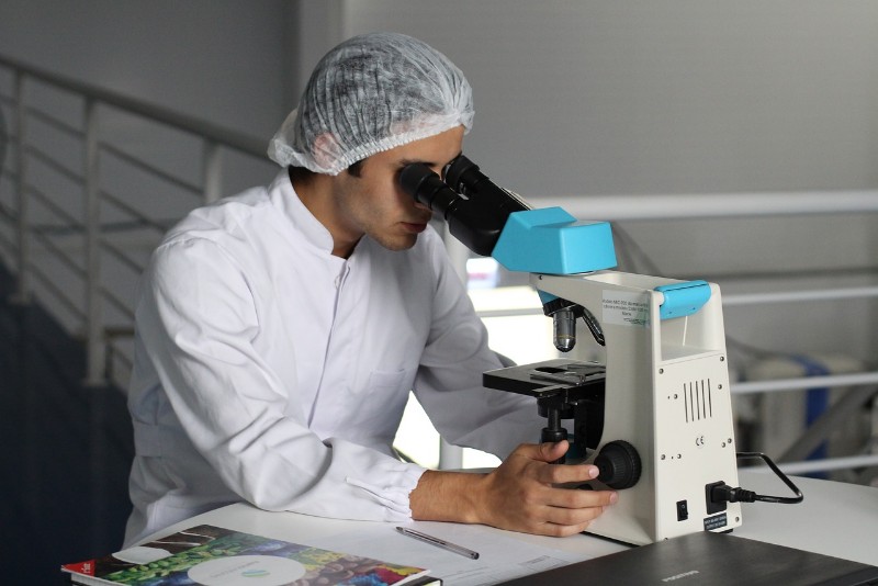 scientist using a microscope