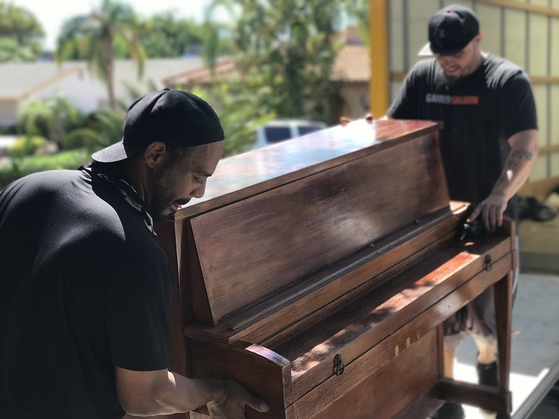 two men moving a heavy piano