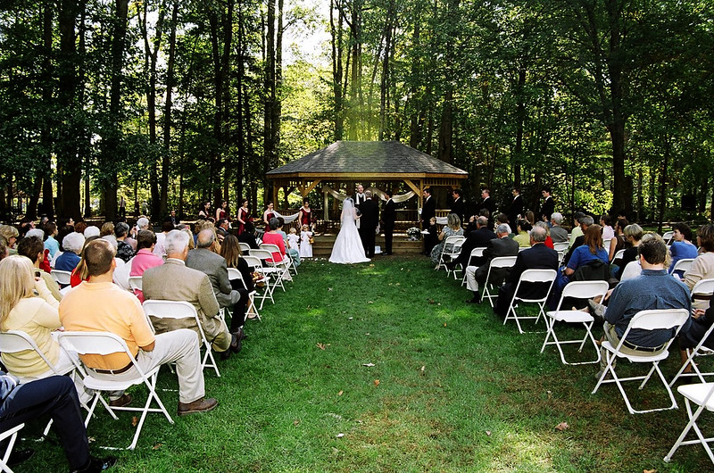 wedding ceremony being performed in the woods